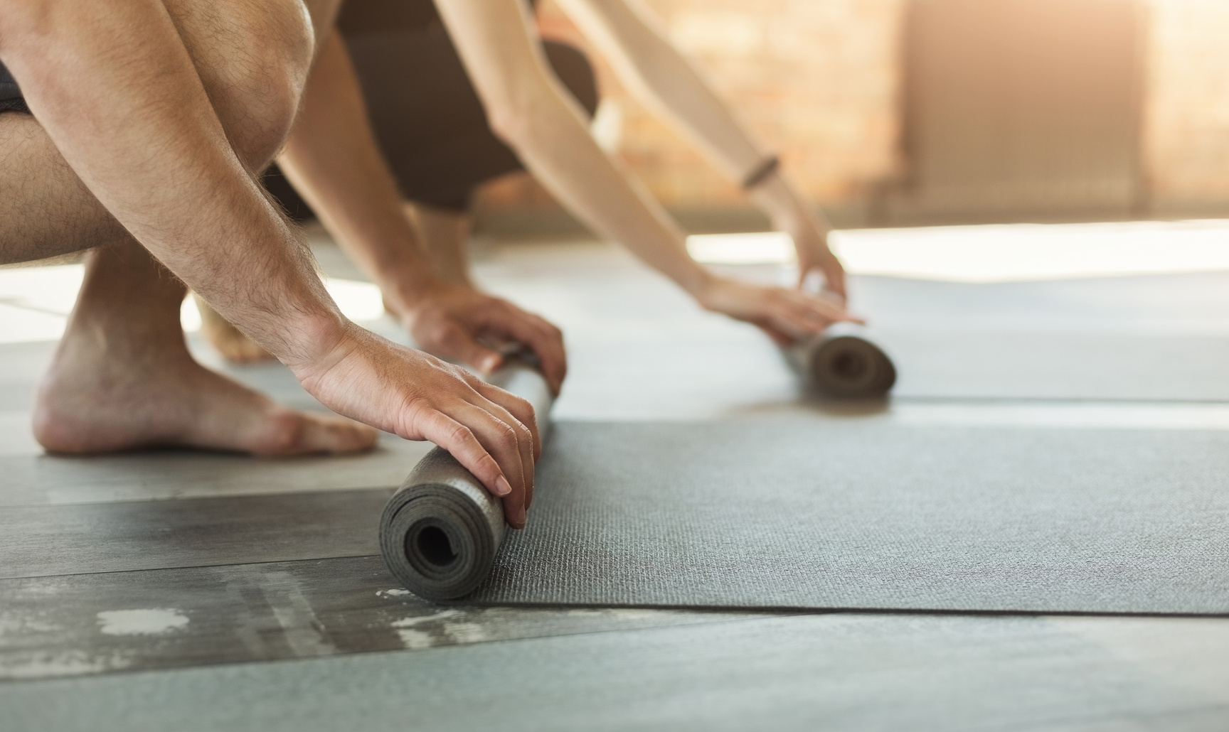 Rolling out yoga mat and preparing to yoga training